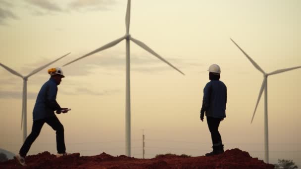 Zwei Ingenieure Diskutieren Der Abenddämmerung Über Pläne Mit Windrädern — Stockvideo