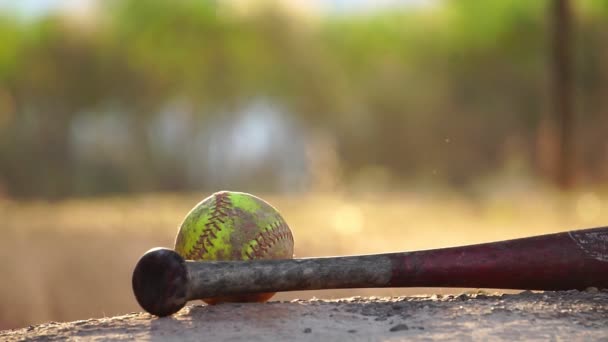 暖かい光の中でアメリカの野球バットとボールのクローズアップ映像選手の手が野球バットを持ち上げて走り — ストック動画