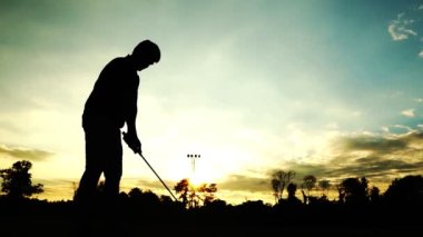 Güzel günbatımında siluet golf oyuncusunun görüntüleri.