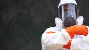 Video Yavaş Hareketi: Koruyucu giysiler içindeki bilim adamı kollarını kavuşturarak ayakta duruyor
