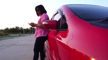 footage of woman calling phone help because her car is broken down, red car on the road and woman asking for help insurance officers