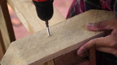 Ahşap paletlerle çalışan matkapçı bir marangoz.