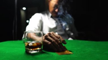 Sigara içen, viski içen ve kumarhanede poker oynayan bir adam. Risk oyunu kavramı, masada poker fişleri