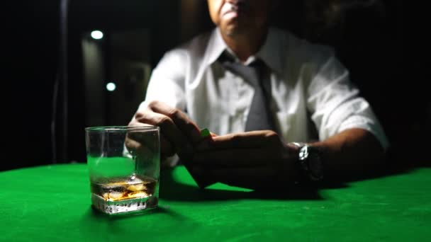 一个人抽烟 喝苏格兰威士忌 在赌场打扑克 危险游戏的概念 桌上的扑克筹码 — 图库视频影像