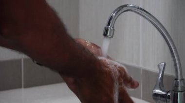 Adamın ellerini lavaboda iyice yıkadığı görüntüler.