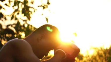  Kırmızı boks eldivenli adam arka planda gün batımında antrenman yapıyor. 