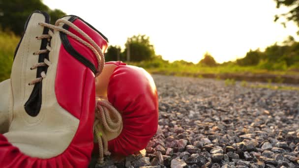 Röda Boxningshandskar Förgrunden Och Siluett Man Som Springer Vid Solnedgången — Stockvideo