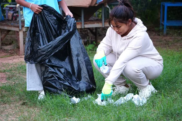 Asyalı kadın kızla çöpleri topluyor..