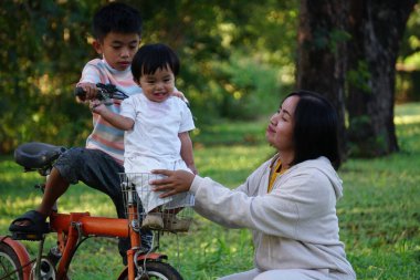Dışarıda bisikletle oynayan Asyalı iki çocuk..