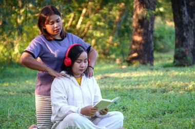 Asyalı kadın arkadaşına yoga minderinde masaj yapıyor..
