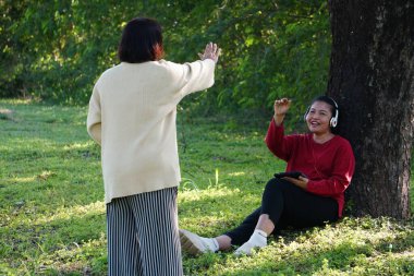 Tabletle ağacın altında konuşan iki kadın.