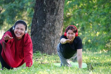 Çimlerin üzerinde yoga yapan iki kadın.