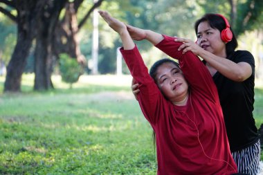 asian woman stretching and exercising with her daughter.