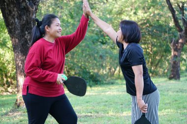 Two women  playing pickleball in park