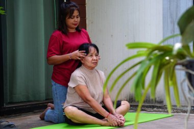 Asyalı kadın yoga minderinde masaj yaptırıyor..