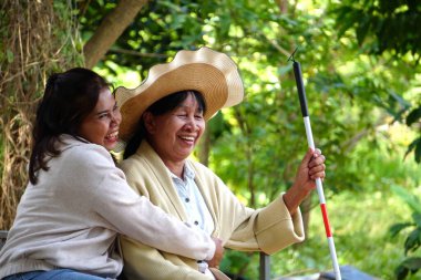 Yeşil alanda yürüyen son sınıf öğrencisi iki kadın..