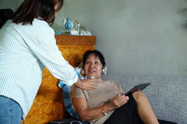 Evde büyükannesiyle birlikte son sınıf öğrencisi Asyalı bir kadın.