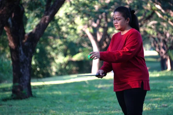 Parkta Pickleball oynayan Asyalı kadın