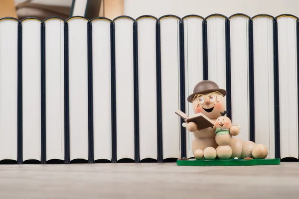 Bookworm voor een rij van boeken — Stockfoto