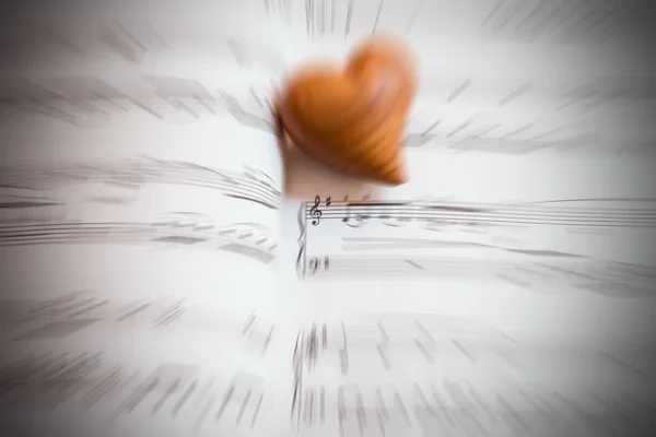 Coração de madeira em uma folha de música — Fotografia de Stock