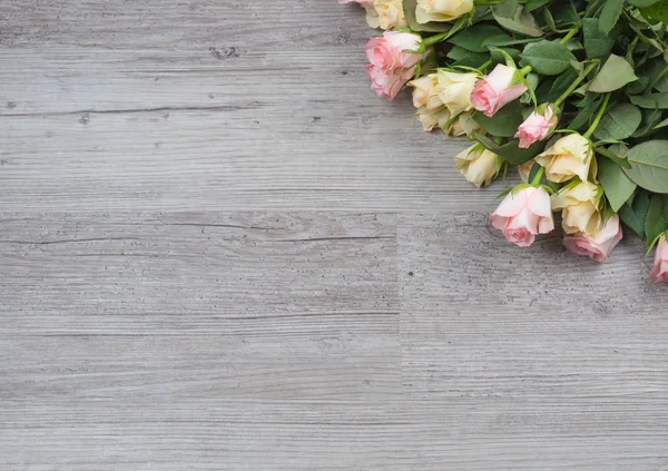 Buquê de rosas sobre mesa de madeira — Fotografia de Stock