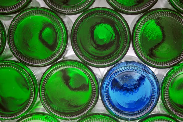 Glass blue bottle among green bottles