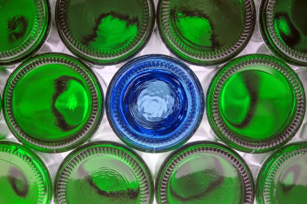 Glass blue bottle among green bottles Stock Picture