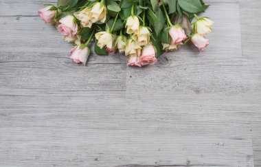 Ahşap masa üzerine pembe ve Sarı gül buketi