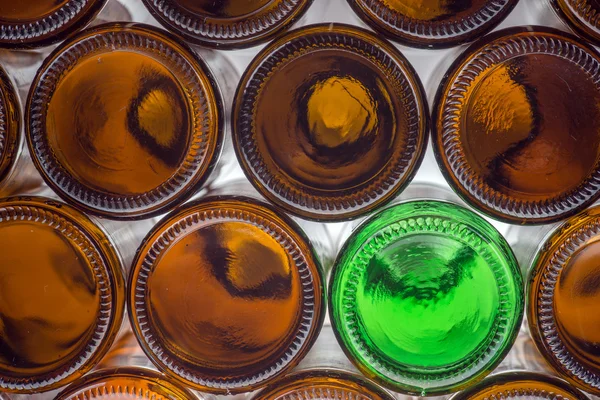 Glass green bottle among brown bottles — Stock Photo, Image