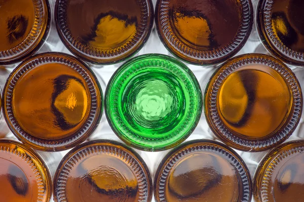 Glass green bottle among brown bottles — Stock Photo, Image