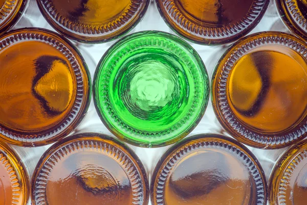 Glass green bottle among brown bottles — Stock Photo, Image