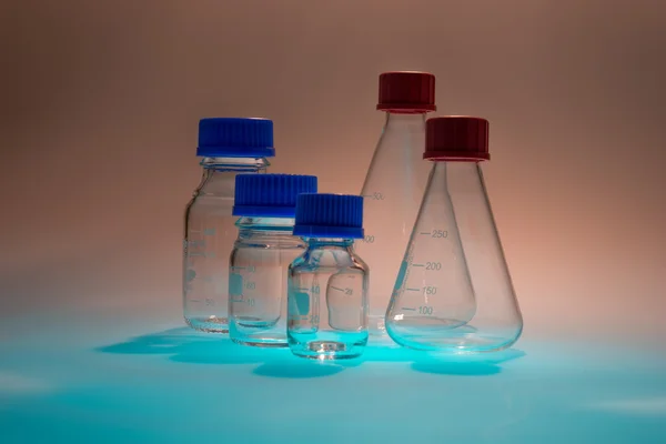 Laborgerät aus Glas isoliert auf blauem Tisch — Stockfoto