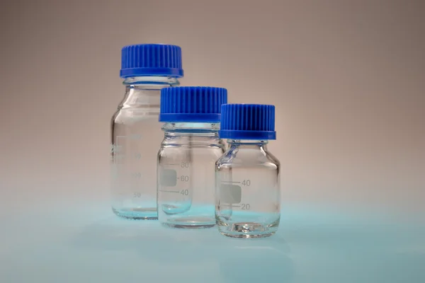 Laborgerät aus Glas isoliert auf blauem Tisch — Stockfoto
