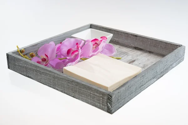 Ciotola bianca con tovagliolo e orchidea su vassoio — Foto Stock