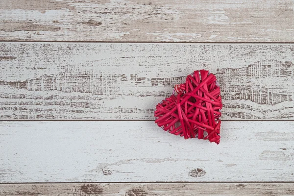 Corazón de madera roja sobre fondo de madera — Foto de Stock