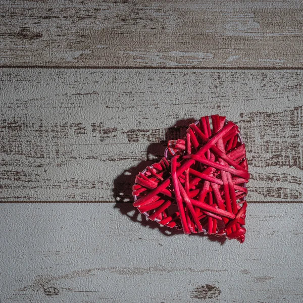 Red wood heart on wooden background