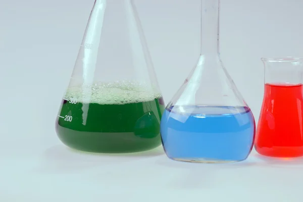 Aparatos de laboratorio de vidrio con agua verde y azul — Foto de Stock