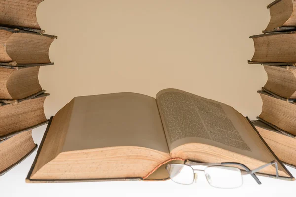 Açık eski kitap ve gözlük masada — Stok fotoğraf
