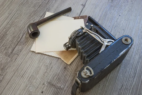 Alte Retro-Kamera mit Tabakpfeife auf Holzbrett — Stockfoto