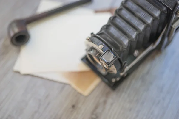 Gamla retro kamera med tobak pipe på träskiva — Stockfoto