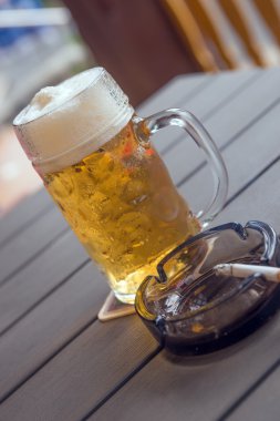 Bira bardağı ve tablo üzerinde Sigara