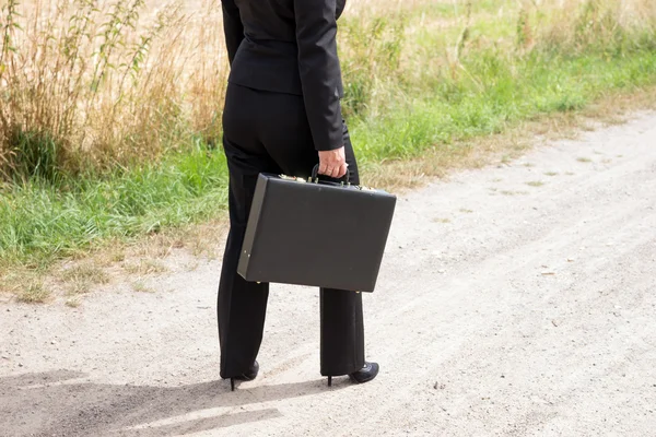 Vrouw op de onverharde weg met werkmap — Stockfoto