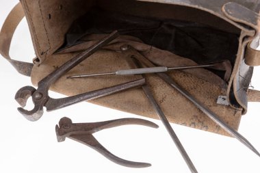 Paslı aletler ve beyaz üzerine izole edilmiş eski bir deri çanta.