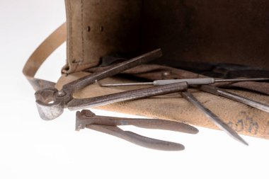 Paslı aletler ve beyaz üzerine izole edilmiş eski bir deri çanta.
