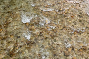 Nehrin dibinde temiz suyla birlikte birçok taş bulunan doğa arka planı.