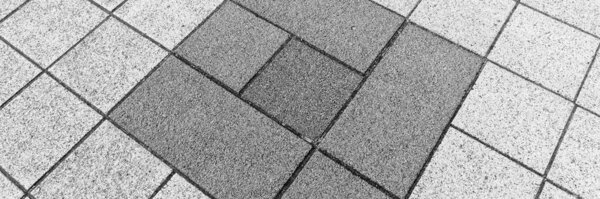 Light and dark gray paving stones in the driveway. Gray background