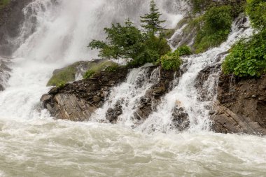 Şiddetli yağmurdan sonra şelale nehre düşer. Kapat.