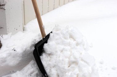 Garaj kapısının önündeki karı temizlemek için kar küreği.