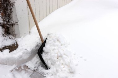 Garaj kapısının önündeki karı temizlemek için kar küreği.