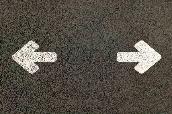 Siyah asfaltta beyaz sağ ve sol ok. Trafik işareti.